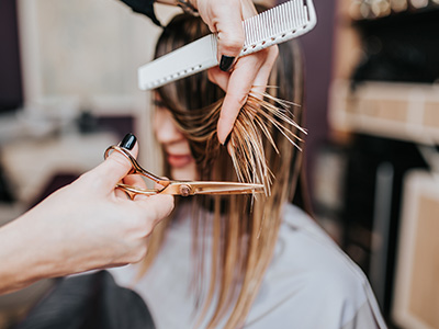 The image shows a hair stylist performing hair treatments, with a close-up view of the stylist s hands using tools on a client s hair.